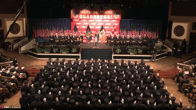 Dozens of probationary EMTs sit in seats at a graduation ceremony. 