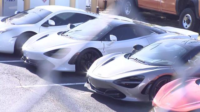 High-end vehicles parked in a parking lot at the McLaren dealership. 