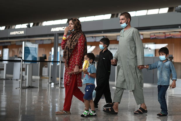 Refugees are led through the departure terminal to a bus at Dulles International Airport after being evacuated from Kabul following the Taliban takeover of Afghanistan on Aug. 31, 2021, in Dulles, Virginia.