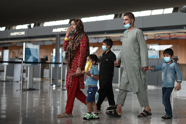 Refugees are led through the departure terminal to a bus at Dulles International Airport after being evacuated from Kabul following the Taliban takeover of Afghanistan on Aug. 31, 2021, in Dulles, Virginia. 