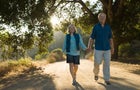 Mature couple walking down dirt road 