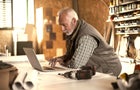 Mature designer looking at laptop 