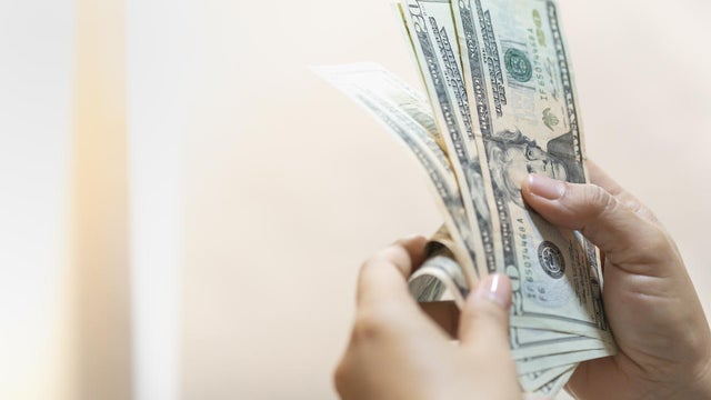 Money Business shopping and saving concept. Close up of woman hand holding and counting US Dollar banknote with copy space. 