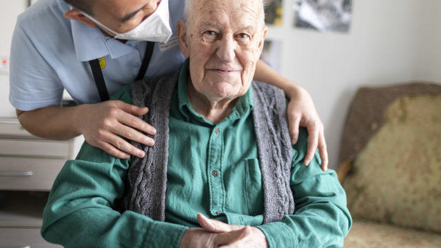 An old man is happy to be touched by a nurse on March 30, 2022 in Heidelberg, Germany. (Photo 