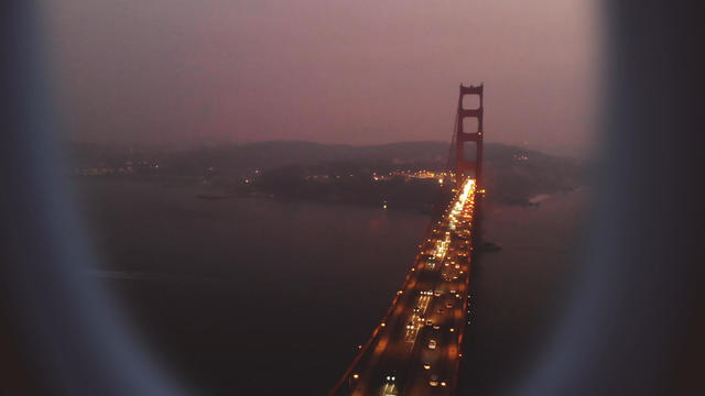 Airplane window view with the Golden Gate bridge at rush night in San Francisco. 