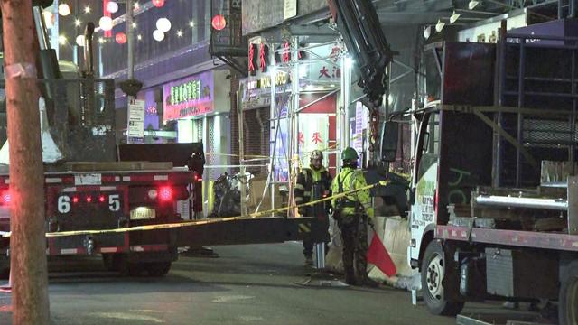 Emergency crews stand outside a Chinatown building. 