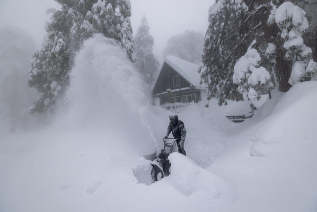 Man uses a snowblower in deep snow in California 