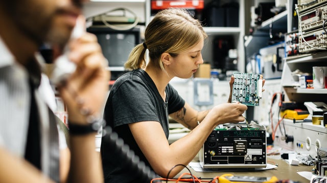 Female Technician Working On Conductor Board 