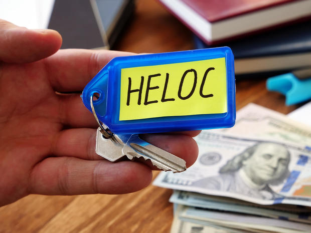 Heloc loan concept. Hand holds key as symbol of property buying. 