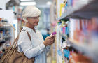 Woman looking at medications on a drug store shelf 