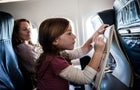 Girl (6yrs) on airplane, drawing on tablet 