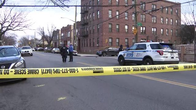 Crime scene tape blocks off the area outside an apartment building. 