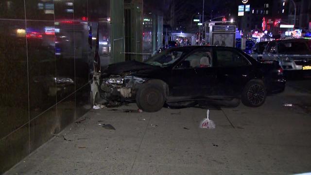 A vehicle sits on a sidewalk after having crashed into the side of a building. 