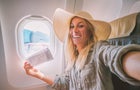Young woman in airplane takes mobile phone selfie portrait during flight 