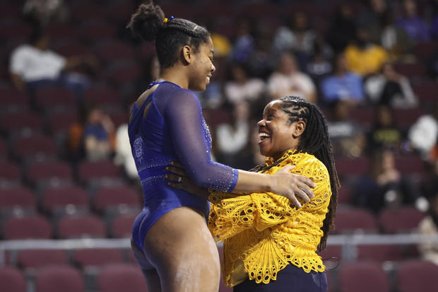 Fisk University gymnastics coach Corrinne Tarver embraces athlete Kiara Richmon. 