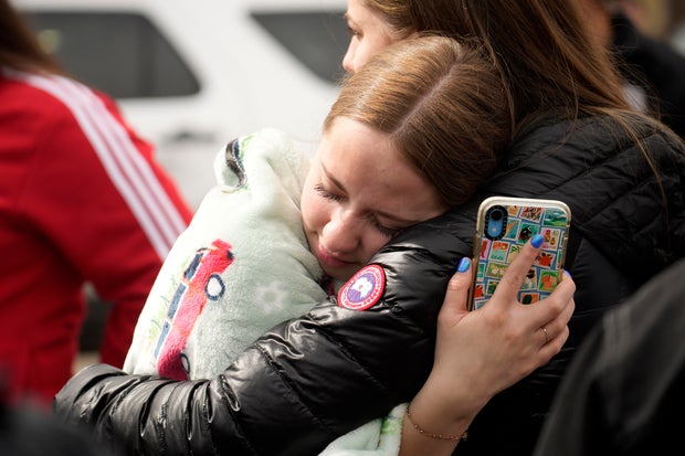 Two women hug following a shooting at Denver's East High School on March 22, 2023.