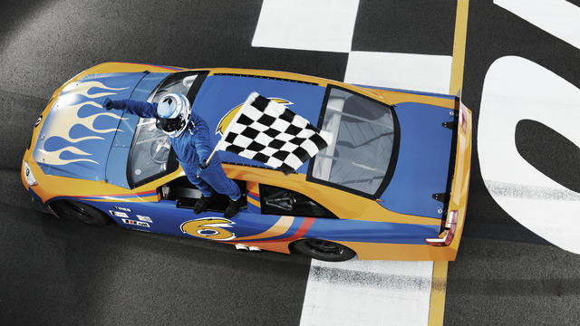 High angle view of driver standing on racecar with checkered flag 
