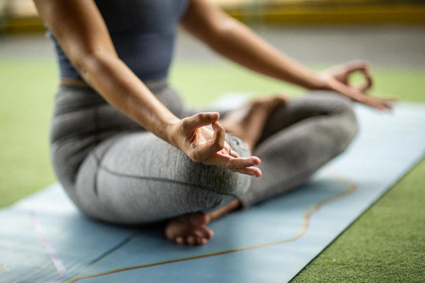 Indonesian woman is meditating in a half lotus position at a gym 