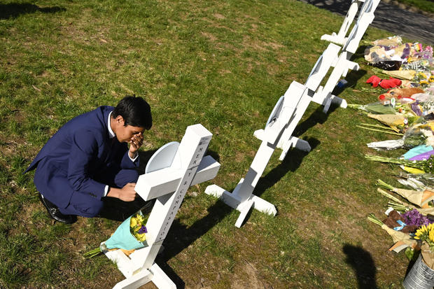 Alexander Reddy, 17, kneels and prays at a cross after leaving flowers at an entry to Covenant School, March 28, 2023, in Nashville, Tenn. 