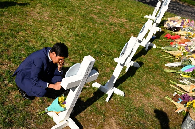 Alexander Reddy, 17, kneels and prays at a cross after leaving flowers at an entry to Covenant School, March 28, 2023, in Nashville, Tenn.