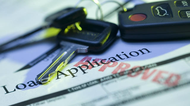 Car keys and approved loan application 