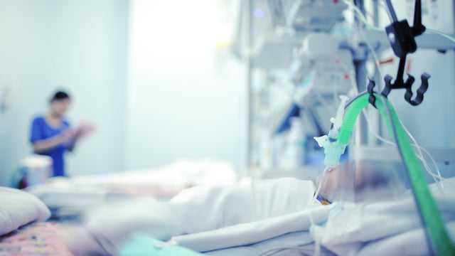 Heavy breathing baby with the help of the apparatus and oxygen in a hospital bed in modern NICU 