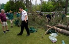 A security guard is seen moving people away from a tree that blew over on the 17th hole at the Masters golf tournament. 