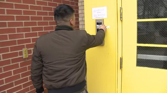 An individual rings a doorbell to be let into a New York City public school. 