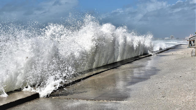 Large wave is crashing into beach wall 