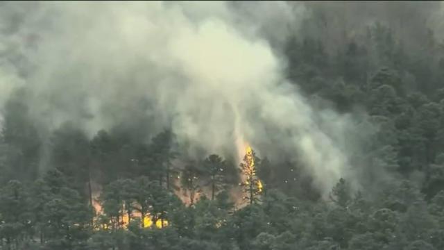 An aerial view of a large cloud of smoke over a wildfire in a wooded area of West Milford. 