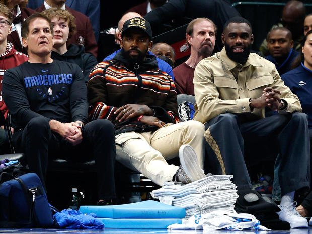 From left, Dallas Mavericks owner Mark Cuban, Kyrie Irving and Tim Hardaway Jr. sit courtside during a game against the Chicago Bulls at American Airlines Center on April 7, 2023, in Dallas, Texas. 