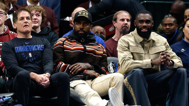 From left, Dallas Mavericks owner Mark Cuban, Kyrie Irving and Tim Hardaway Jr. sit courtside during a game against the Chicago Bulls at American Airlines Center on April 7, 2023, in Dallas, Texas. 