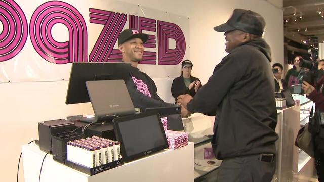The owner of Dazed Cannabis Dispensary stands behind the counter at the store. 