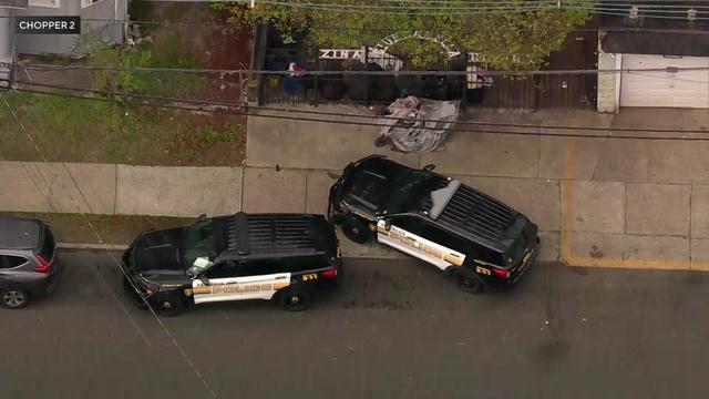 An aerial view of two Paterson Police vehicles parked on a residential street. 