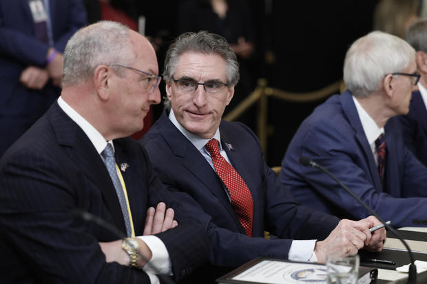 Louisiana Governor John Bel Edwards (left) speaks with North Dakota Governor Doug Burgum (center) before the start of a meeting between President Biden and governors visiting from states around the country in the East Room of the White House on February 10, 2023. 