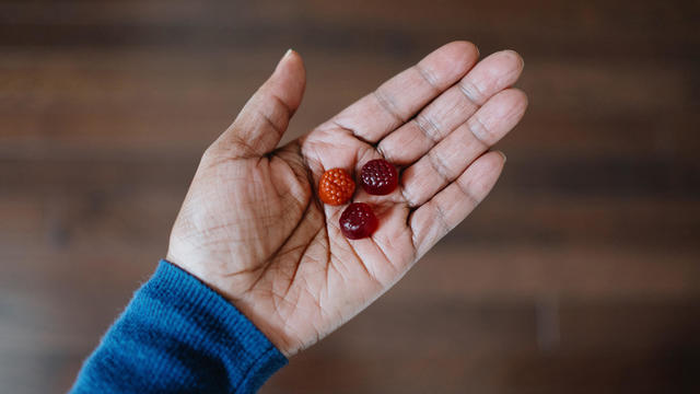 Woman Holds Fruit-Flavored Gummy Nutritional Supplements 