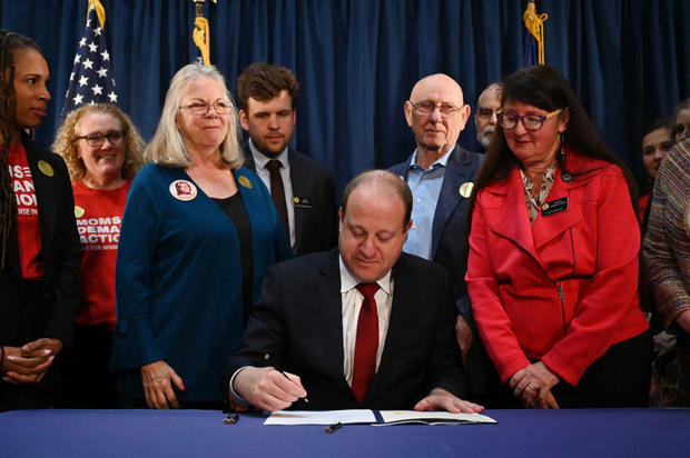 Gov. Jared Polis signed four gun control bills by Sandy and Lonnie Phillips, parents of Aurora theater shooting victim Jessica Ghawi, at the governor's office in Colorado State Capitol Building in Denver, Colorado on Friday, April 28, 2023. 