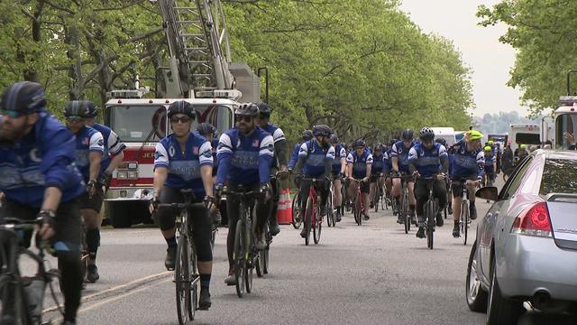 Dozens of police officers on bicycles ride through the streets of Jersey City. 