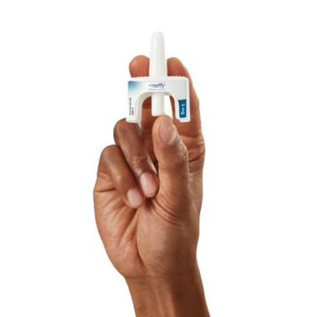 A hand holding a Neffy nasal spray device 