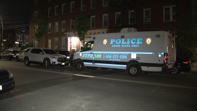 An NYPD crime scene unit vehicle parked outside a Brooklyn apartment building. 