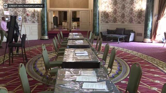 Tables and chairs are set up in a large room inside the Roosevelt Hotel. 