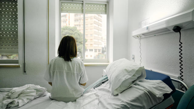 sick woman alone in a hospital room 