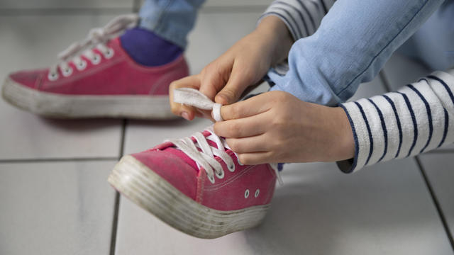 Closeup of child tying her shoelaces 
