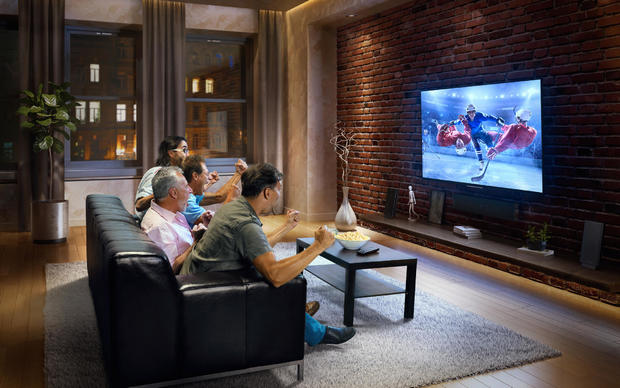 Four men watching hockey game on TV 