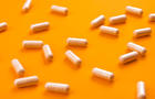 Beige pills on a bright orange background 