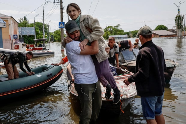 Volunteers evacuate local residents from a flooded area after the Nova Kakhovka dam breached, in Kherson 