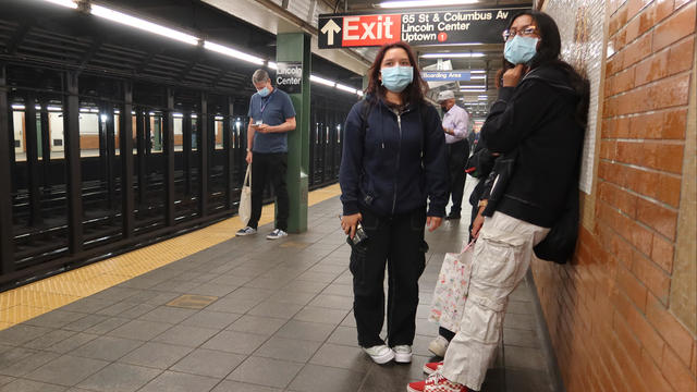 People wear masks as they wait for a subway train to protect themselves from smoke drifting into the Lincoln Center station on June 7, 2023, in New York City. 