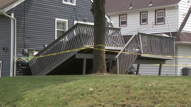 A backyard deck is partially collapsed. 