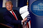 President Donald Trump holds up papers as he speaks about the coronavirus in the James Brady Press Briefing Room of the White House on April 20, 2020, in Washington. 