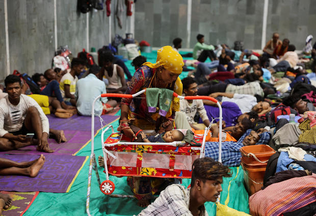 Laxmi Kumar places her son Arvind in a cradle at a temporary shelter for people evacuated from Kandla port, before the arrival of Cyclone Biparjoy, in Gandhidham, Gujarat state, India, June 13, 2023. 